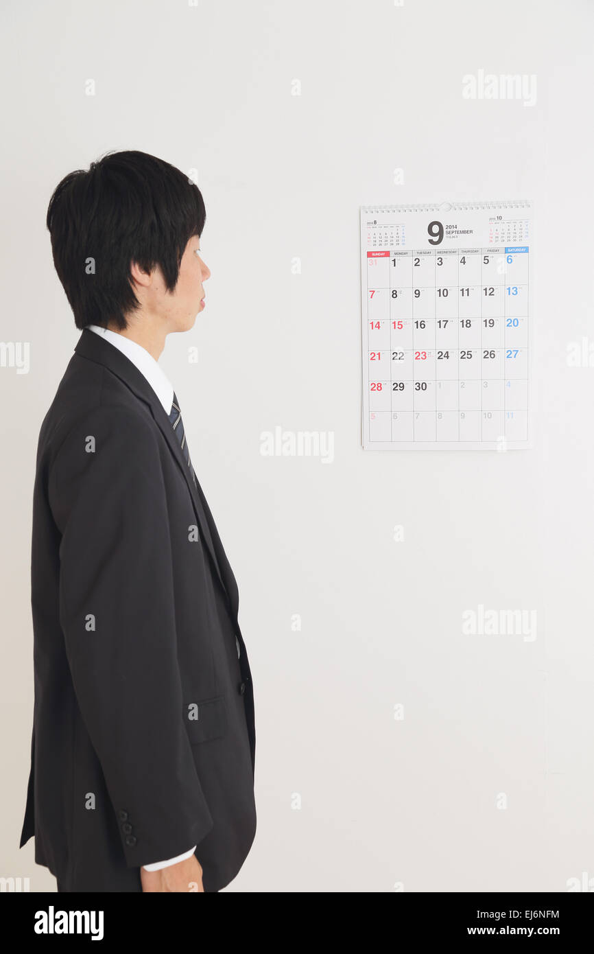 Young Japanese businessman looking at the calendar Stock Photo