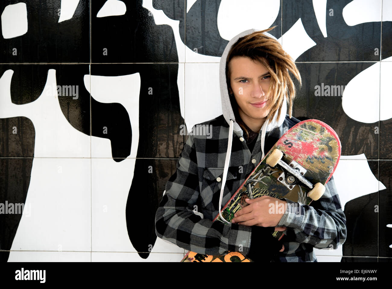 portrait of young guy  with skate and rasta hair in a lifestyle concept Stock Photo