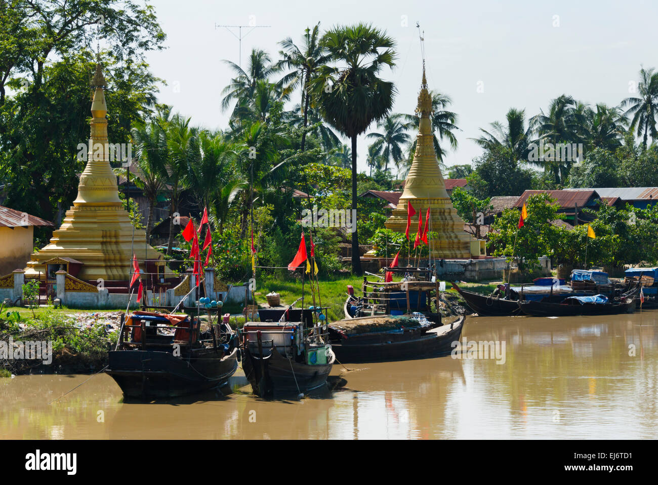 Fishing boats on the river and pagodas on the river bank, Bago Region, Myanmar Stock Photo