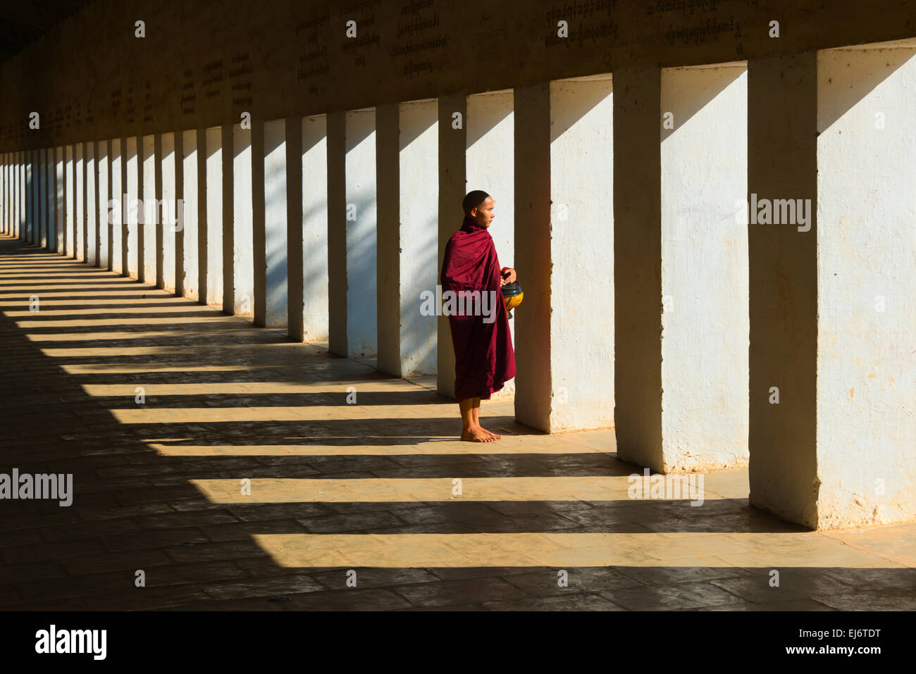 Monk in corridor with light streaming through, Bagan, Mandalay Region, Myanmar Stock Photo