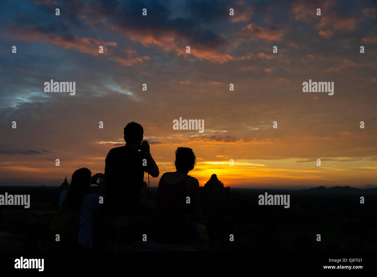 Tourists photographing ancient temple and pagoda at sunrise, Bagan, Mandalay Region, Myanmar Stock Photo