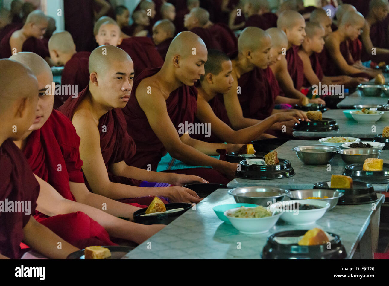 Monks eating a meal at Mahagandayon Monastery, Amarapura, Manadalay, Myanmar Stock Photo