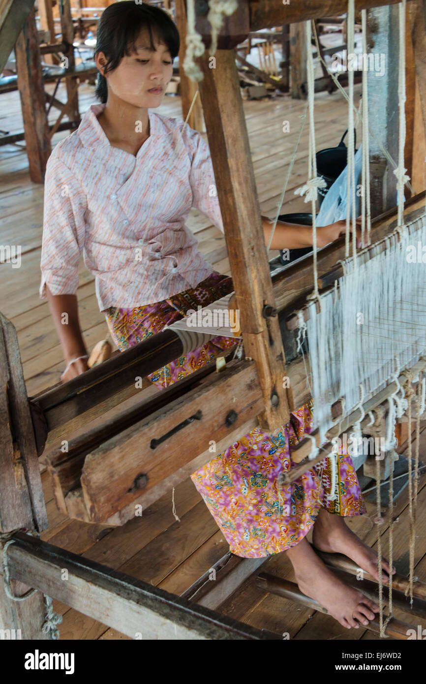 Girl weaving threads made from lotus stem by the loom, Inle Lake, Shan State, Myanmar Stock Photo