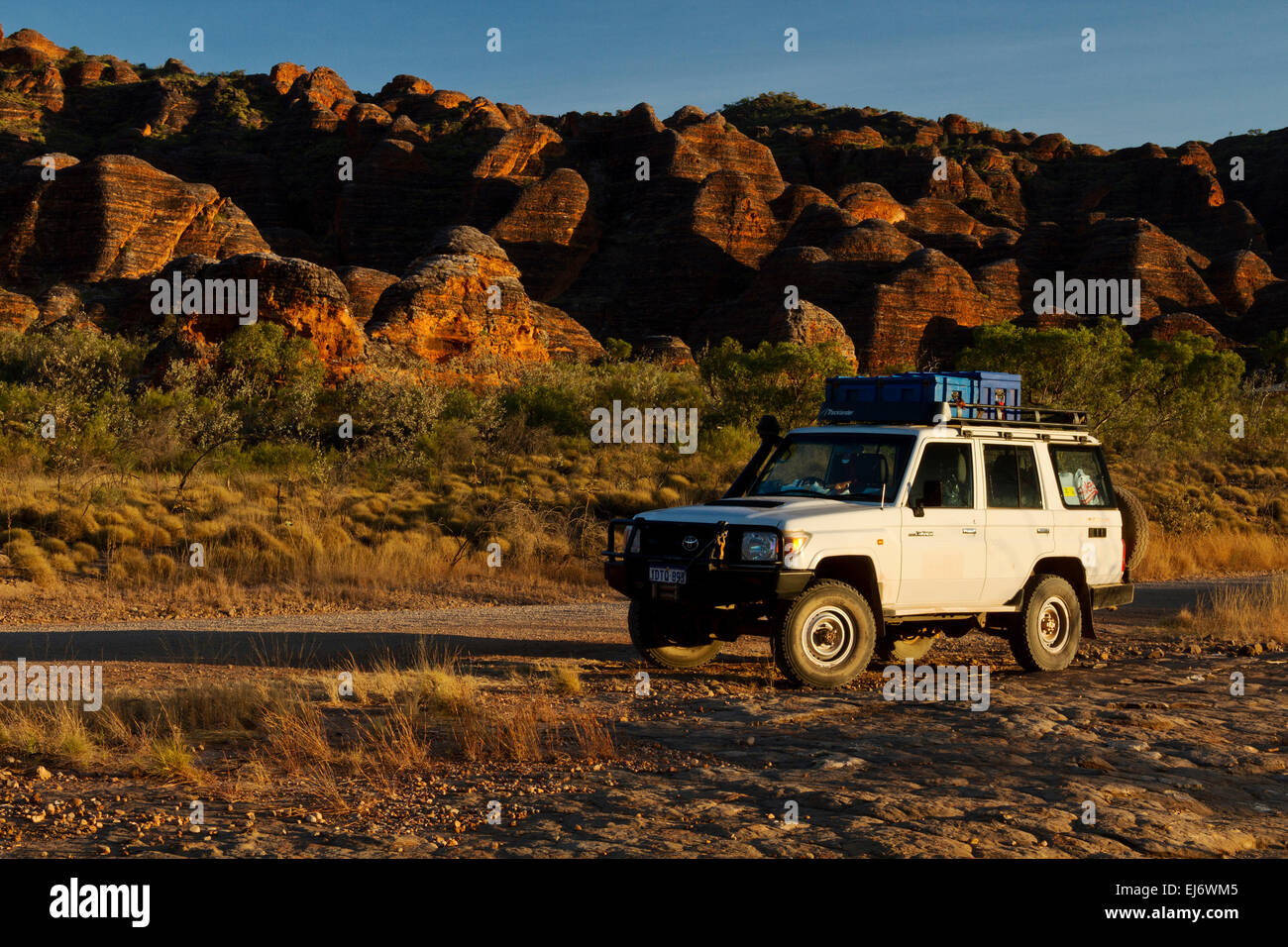 4WD at sunrise in the Bungle Bungles of Western Australia with beehive-shaped cone karst towers in the background Stock Photo
