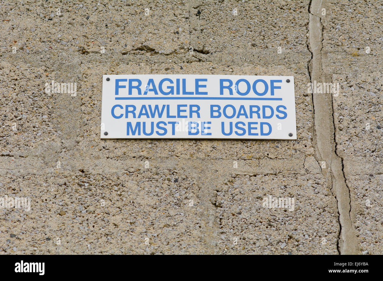 Fragile roof crawler boards must be used sign on wall Stock Photo