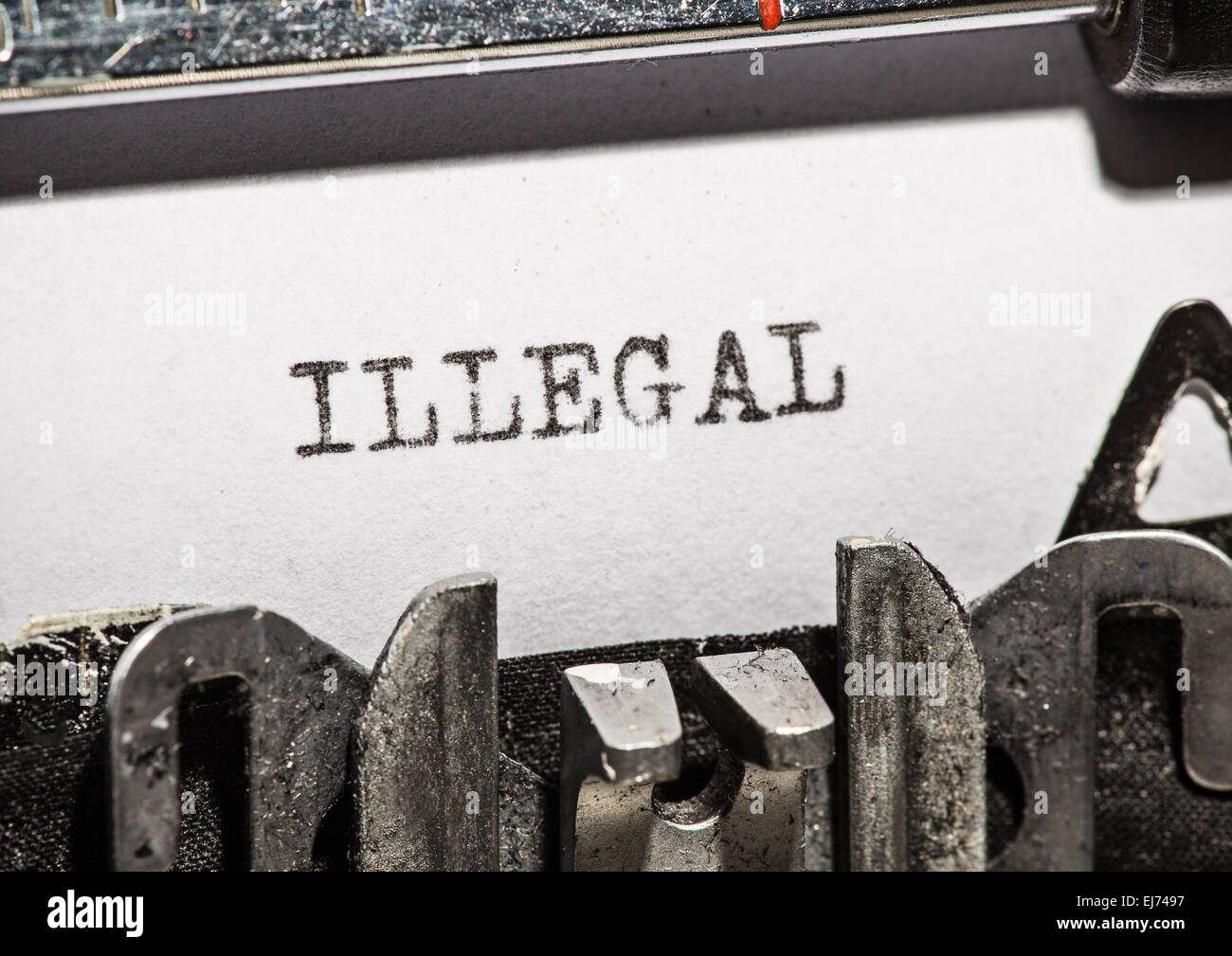 Typewriter with white paper page on wooden table. sample text Illegal