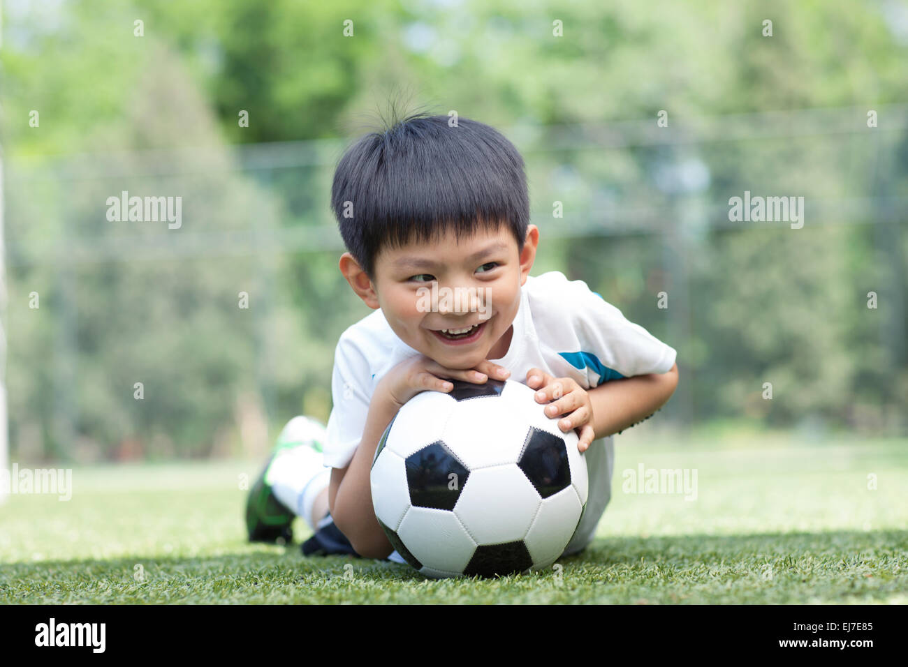 Une petite fille joueur de football frappe une balle sur le terrain de jeu  Photo Stock - Alamy