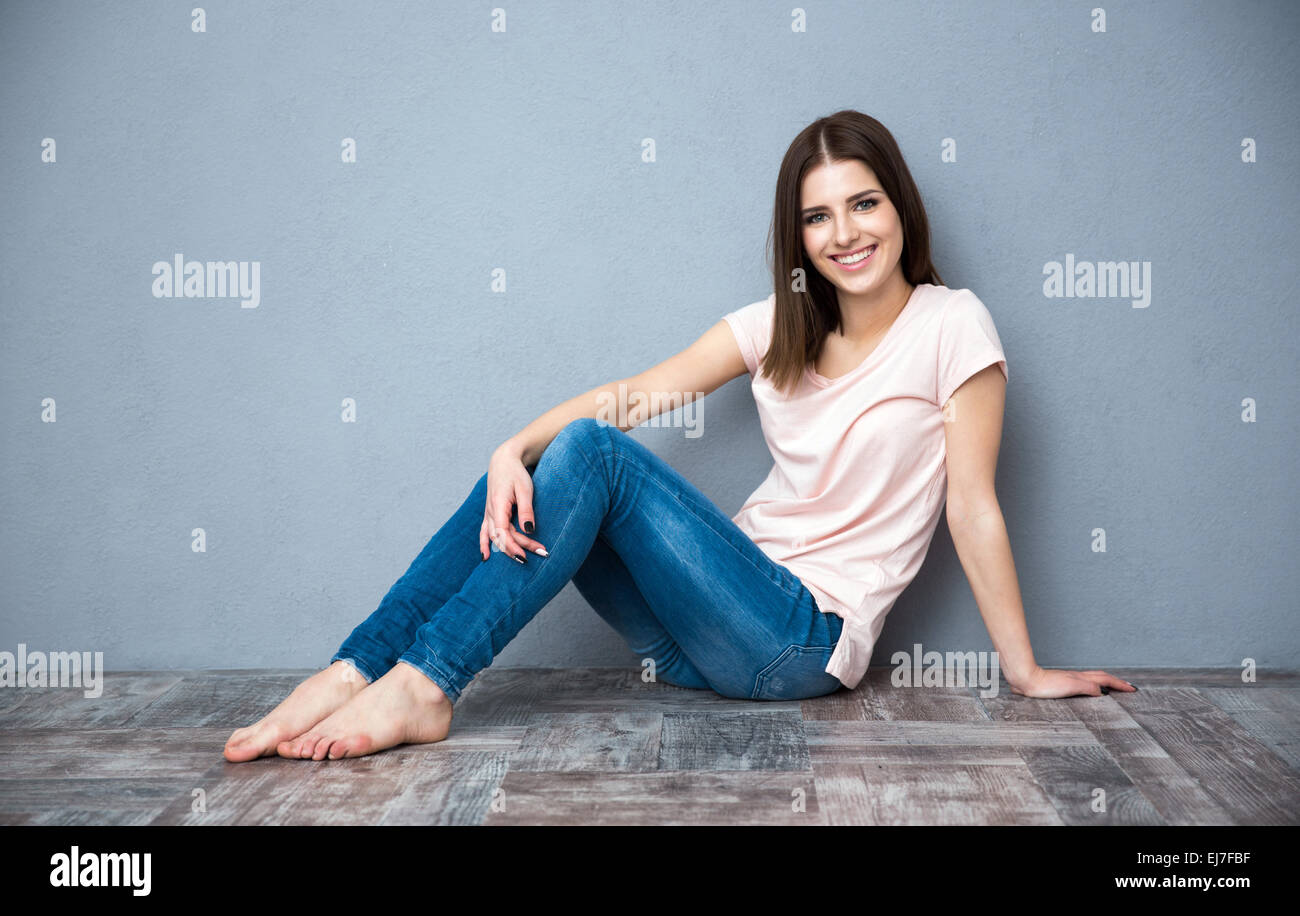 Happy beautiful woman sitting on the floor Stock Photo - Alamy