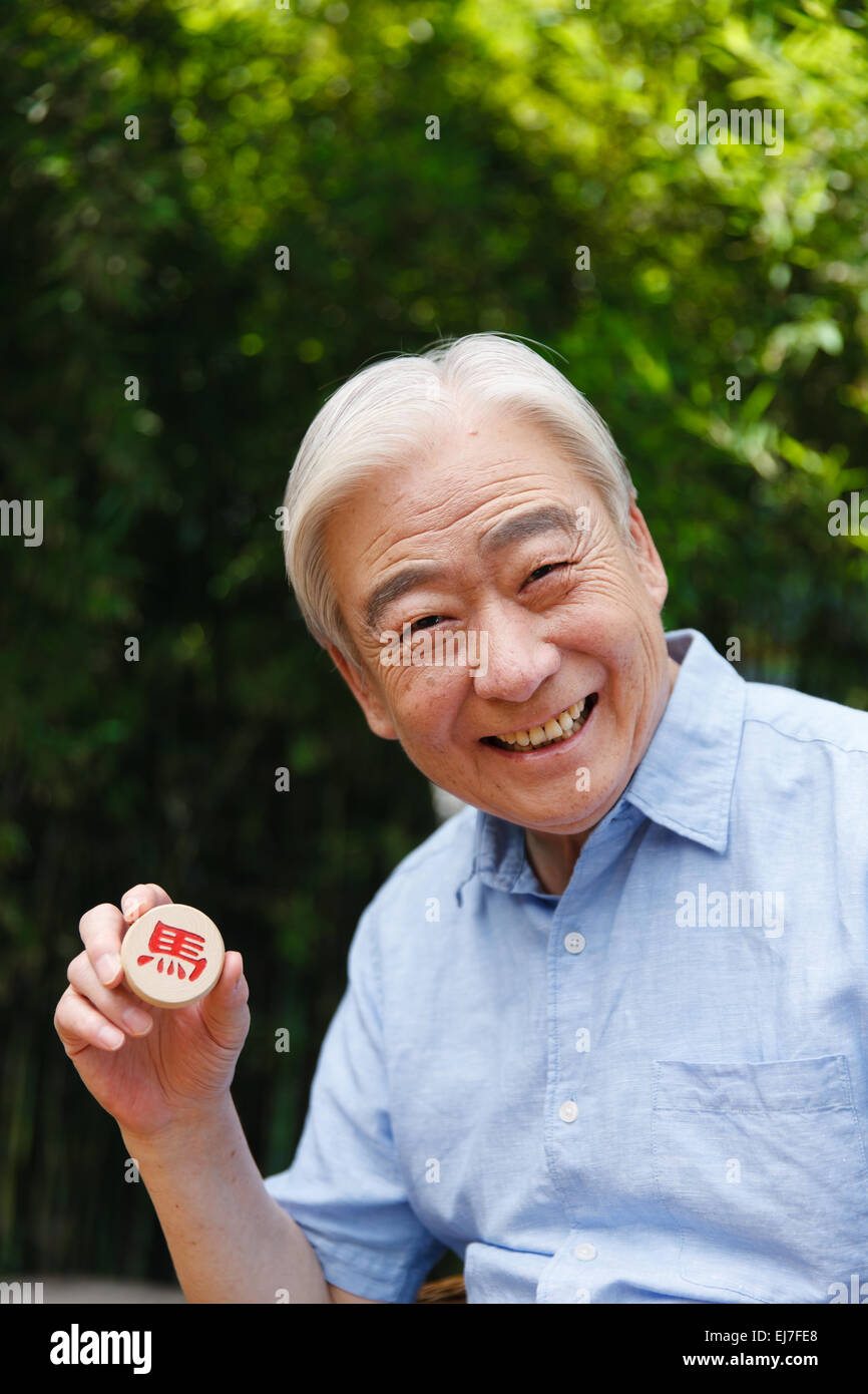 An old man with a Chinese chess Draughtsman Stock Photo