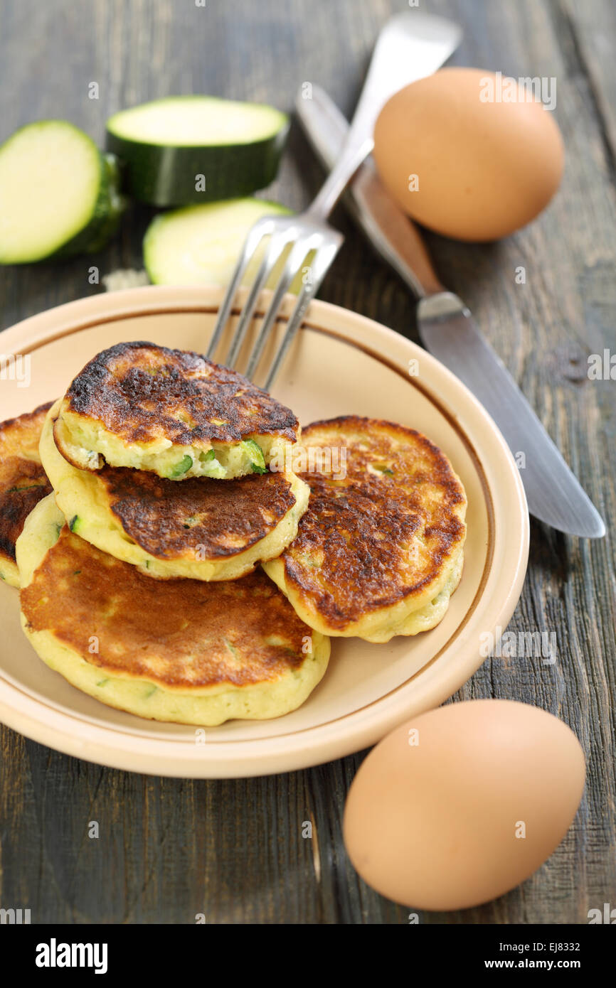 Zucchini fritters and fork on a plate Stock Photo Alamy