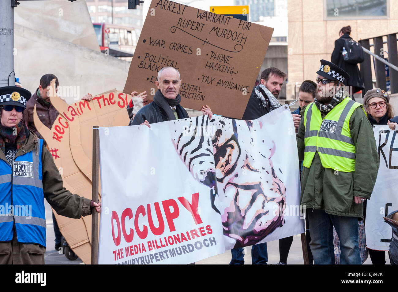 London Bridge Station, London, UK.  23rd March, 2015. Donnachadh McCarthy, Occupy spokesperson, centre, pictured with demonstrators gathering outside News UK's headquarters, 'the Little Shard' near London Bridge as part of the Occupy Rupert Murdoch protest.  The protest is against the dominance of billionaire owners of UK media: Rupert Murdoch (News UK), Viscount Rothermere (Daily Mail Group), Richard Desmond (The Express) and the Barclay brothers (Telegraph). Credit:  Stephen Chung/Alamy Live News Stock Photo