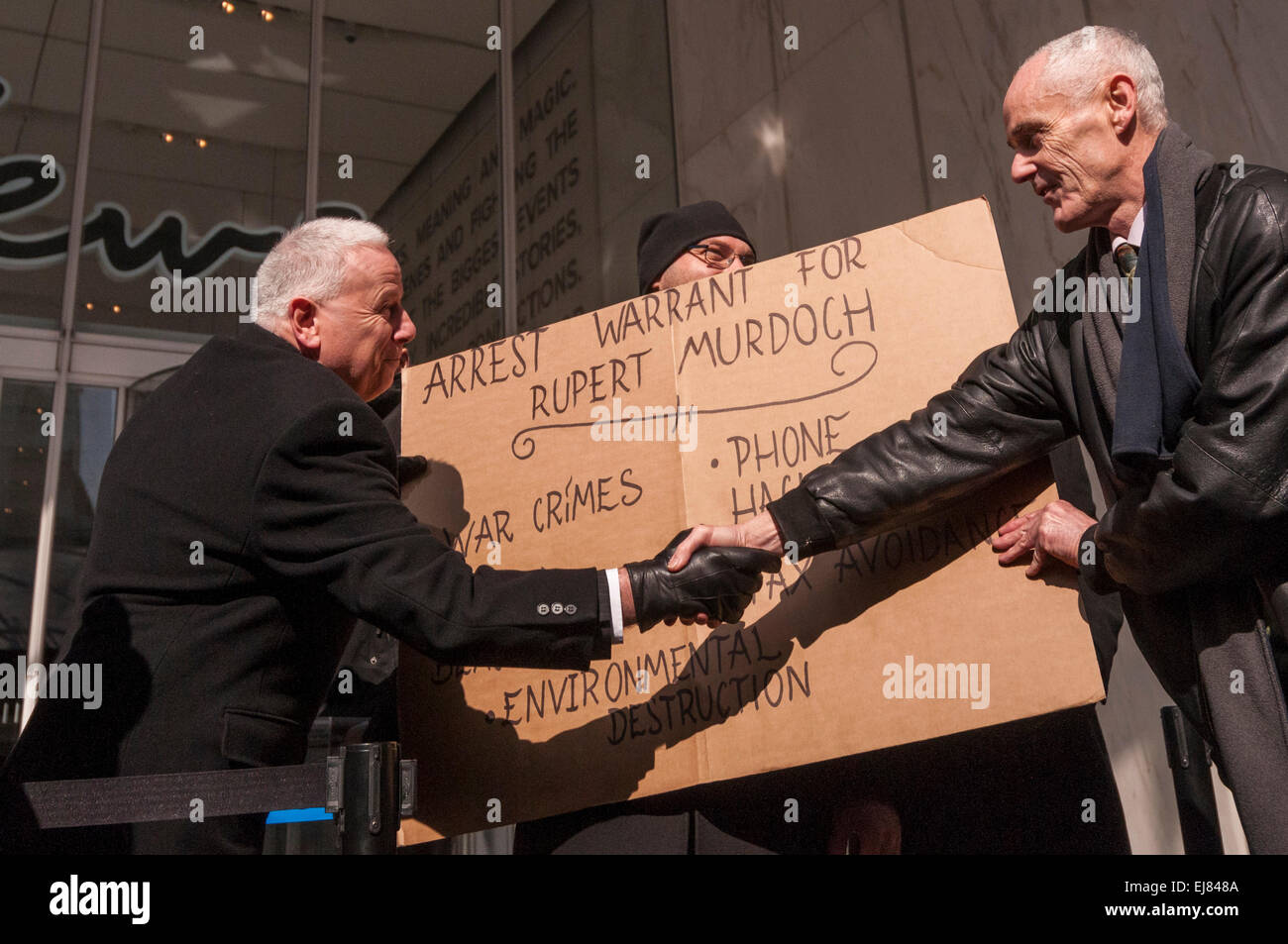 London Bridge Station, London, UK.  23rd March, 2015. Donnachadh McCarthy, Occupy spokesperson, pictured handing over a symbolic arrest warrant for Rupert Murdoch to a member of News UK's staff outside News UK's headquarters, 'the Little Shard' near London Bridge as part of the Occupy Rupert Murdoch protest.  The protest is against the dominance of billionaire owners of UK media: Rupert Murdoch (News UK), Viscount Rothermere (Daily Mail Group), Richard Desmond (The Express) and the Barclay brothers (Telegraph). Credit:  Stephen Chung/Alamy Live News Stock Photo