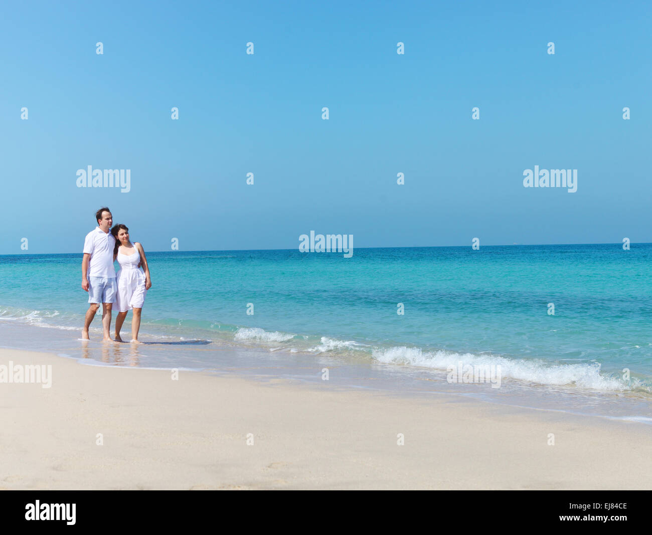 Young happy couple walking on the beach Stock Photo