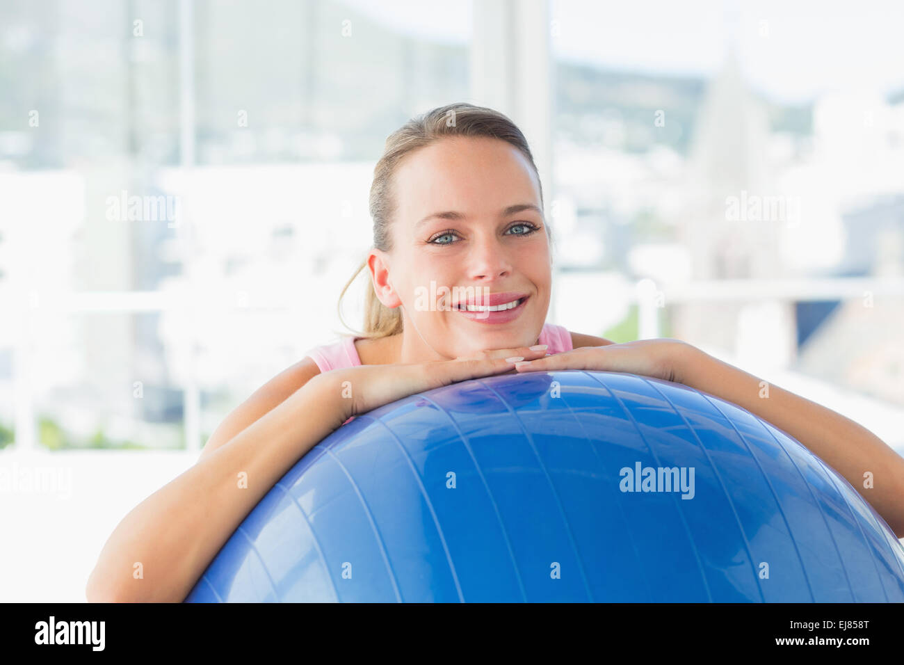 Smiling fit woman with exercise ball at gym Stock Photo - Alamy
