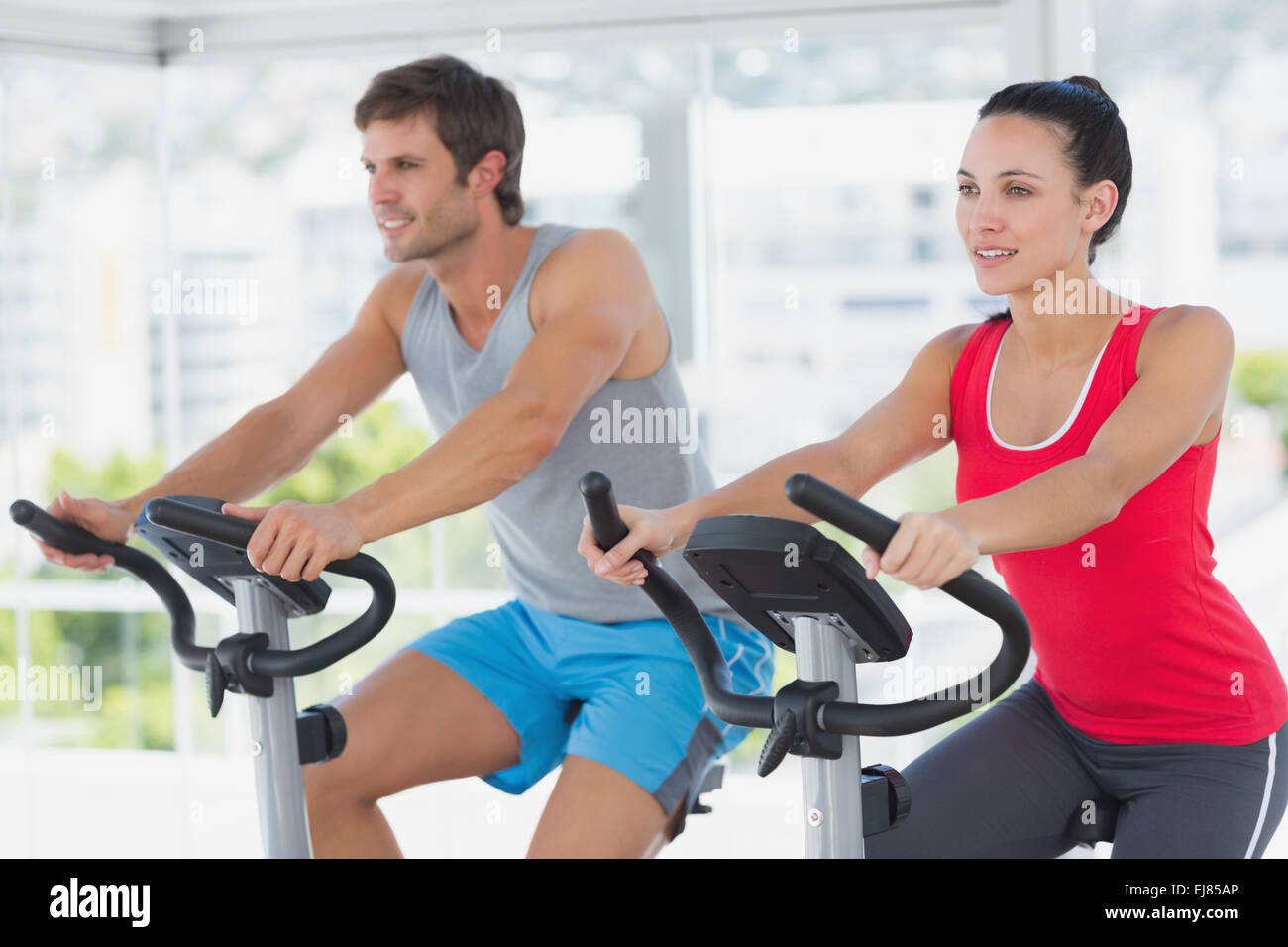 Fit young couple working out at spinning class Stock Photo - Alamy