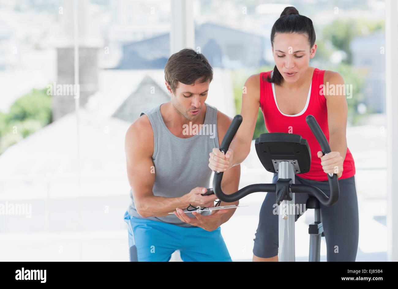 Woman with male instructor working out at spinning class Stock Photo ...