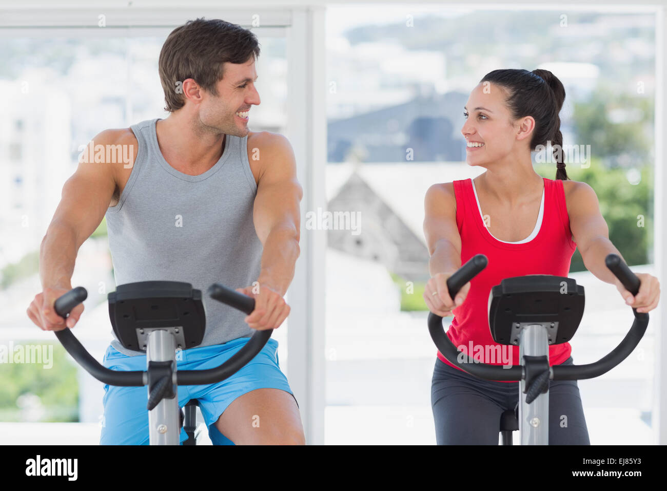 Couple working out at spinning class in bright gym Stock Photo - Alamy