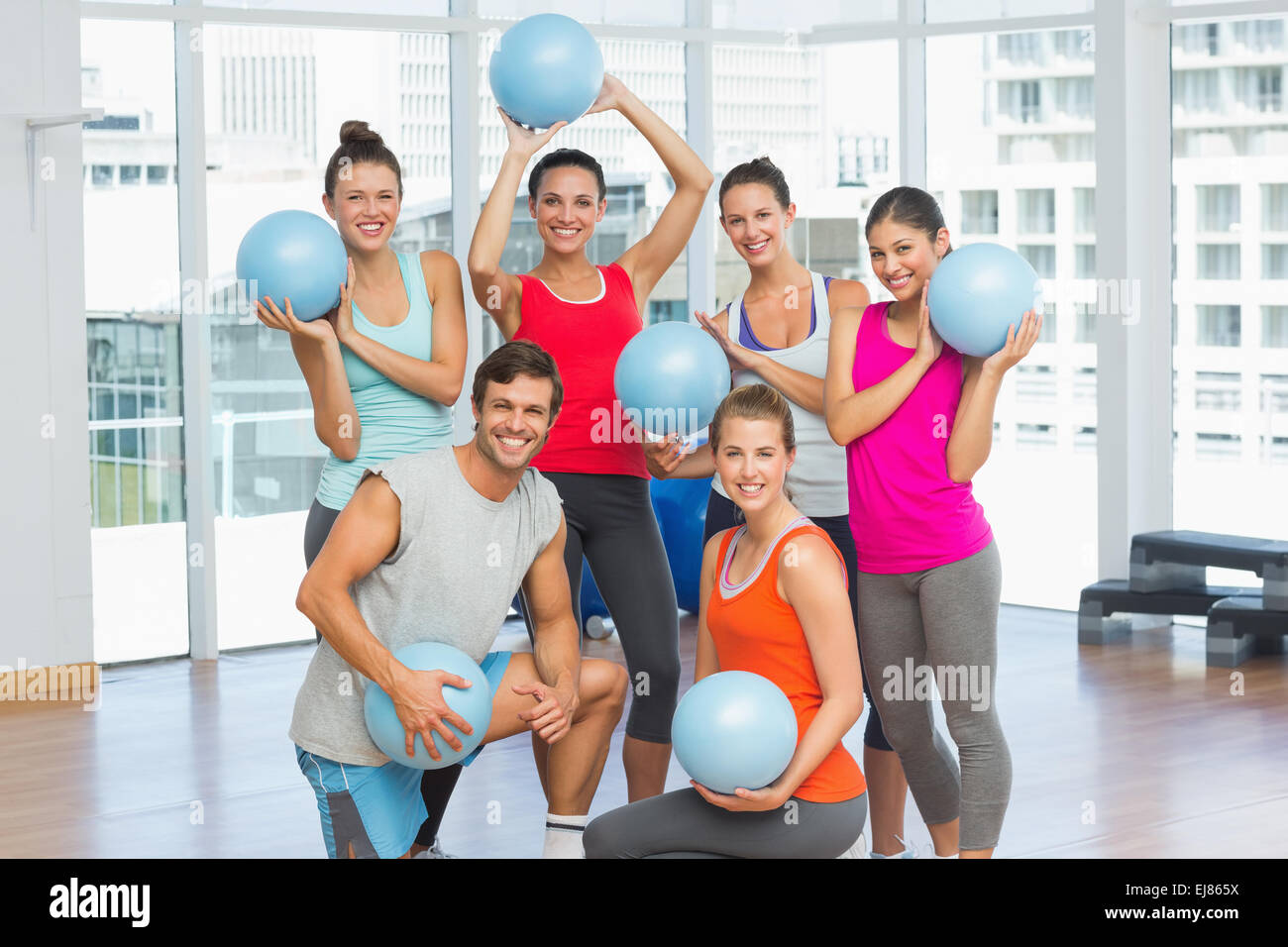 Fit young people with balls in exercise room Stock Photo - Alamy