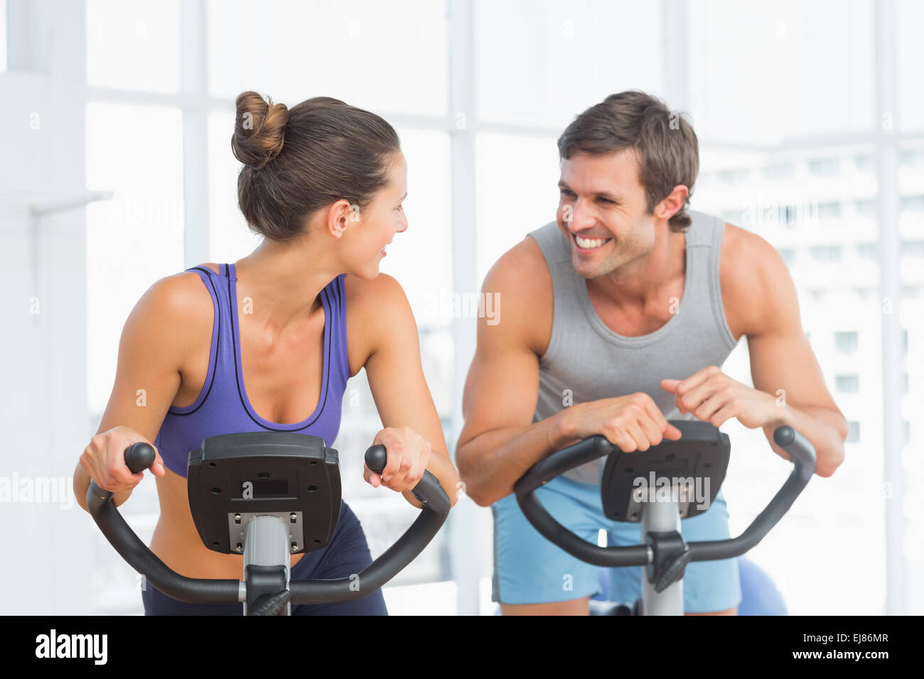Smiling young couple working out at spinning class Stock Photo - Alamy