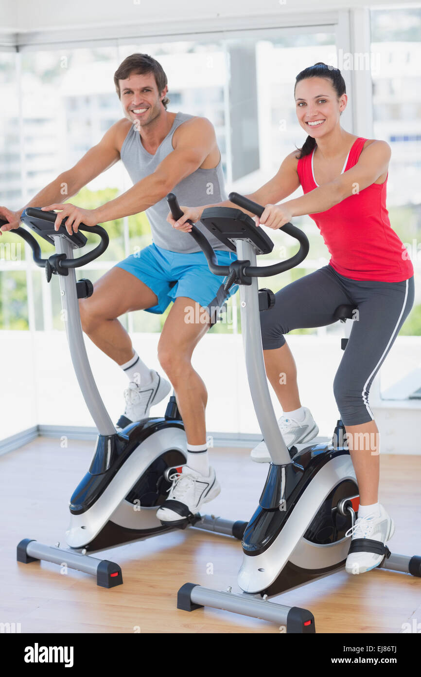 Smiling young couple working out at spinning class Stock Photo - Alamy