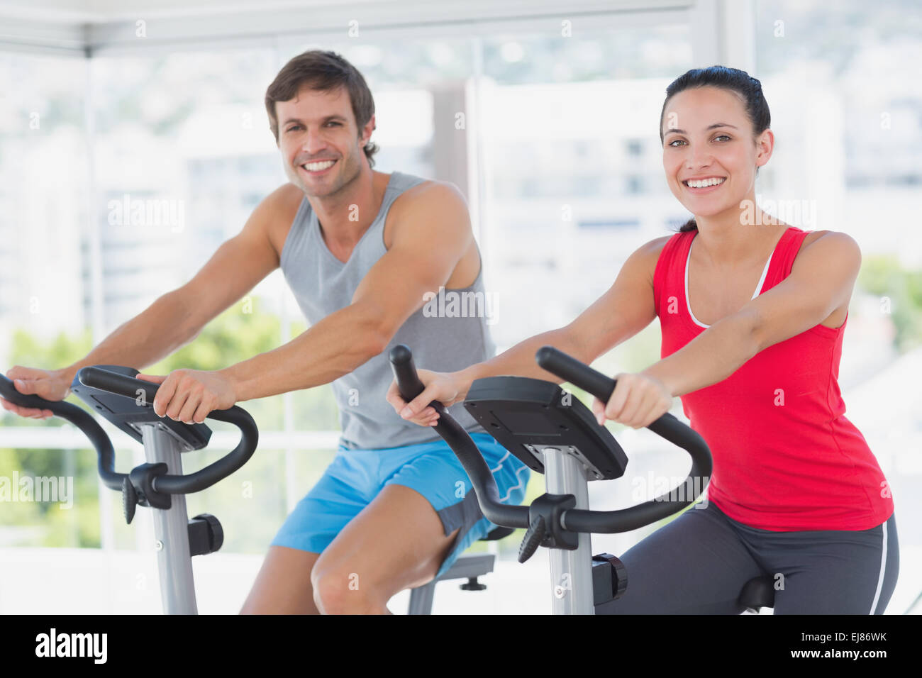 Smiling young couple working out at spinning class Stock Photo - Alamy