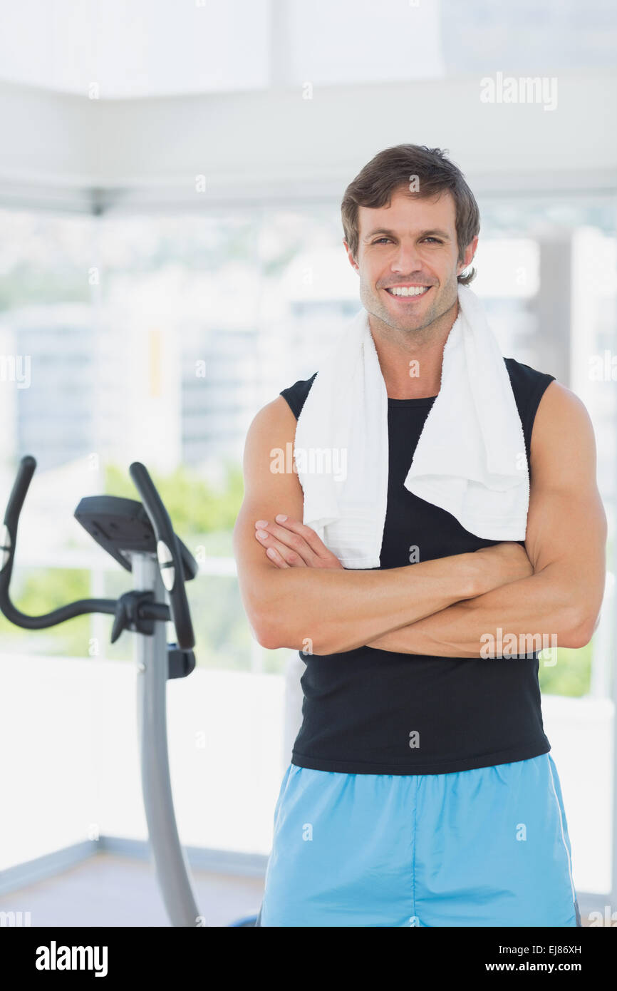 Smiling man with arms crossed at spinning class in bright gym Stock ...