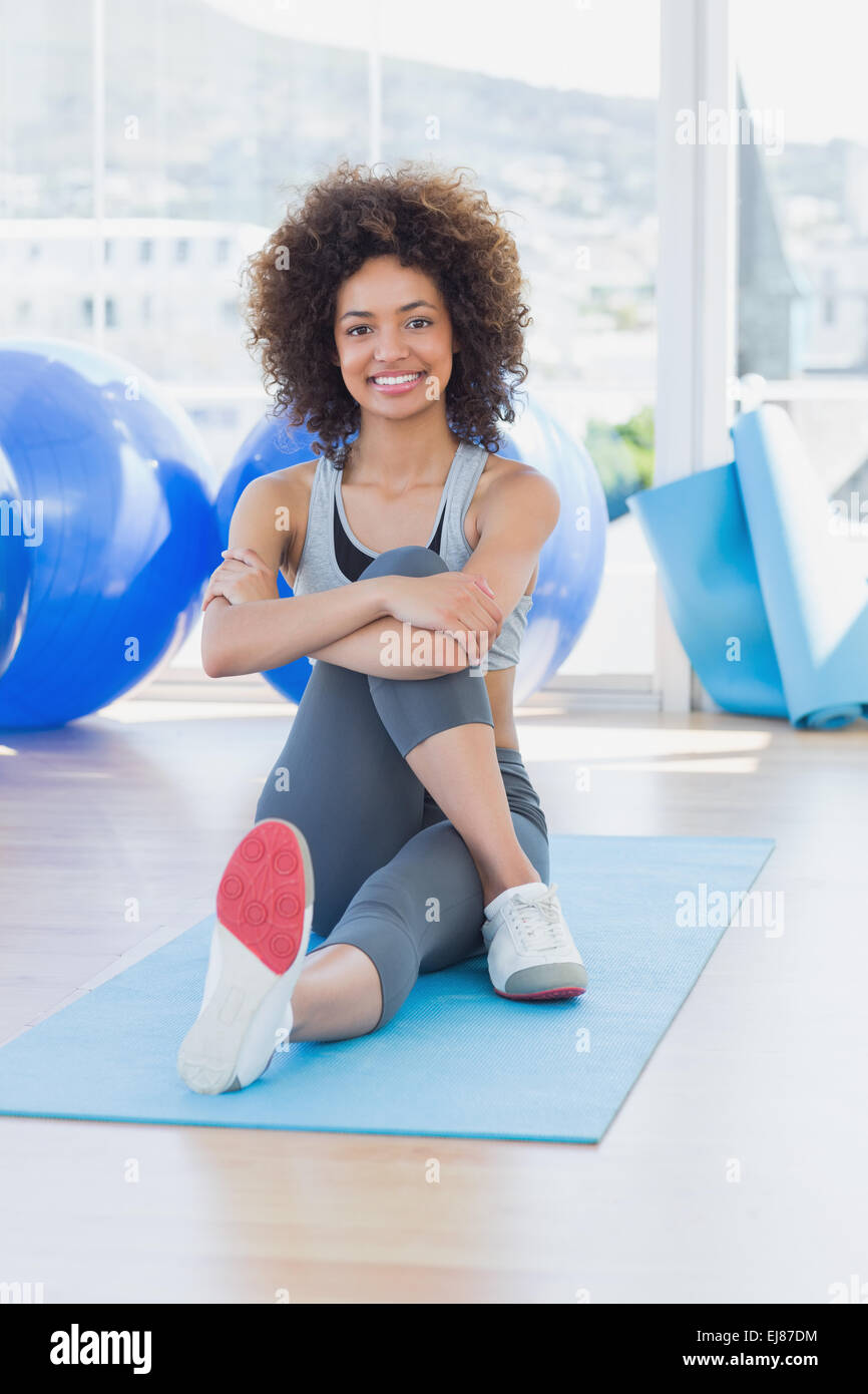 Fit woman sitting on exercise mat in fitness studio Stock Photo - Alamy