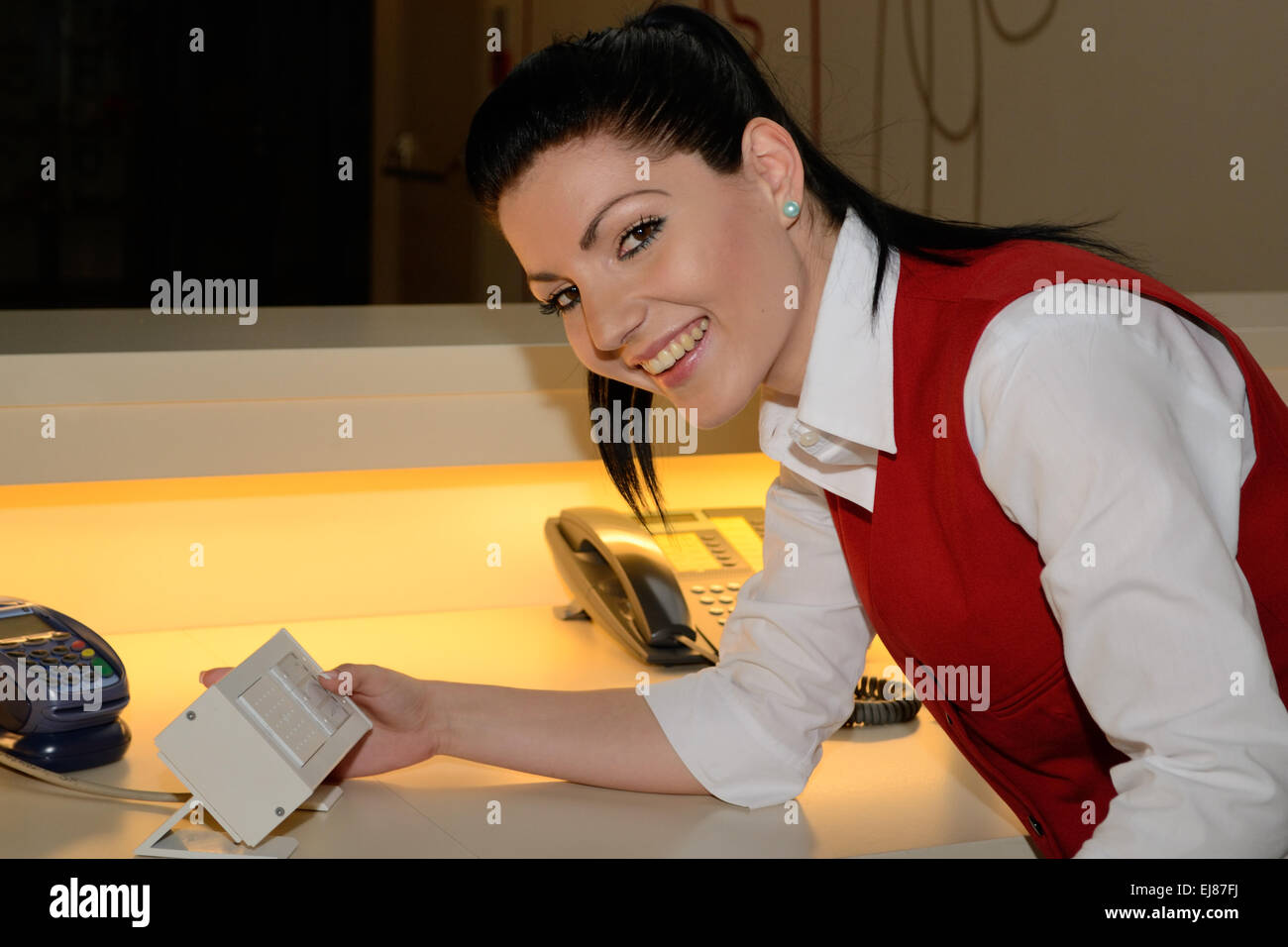 Receptionist smiles while talking Stock Photo