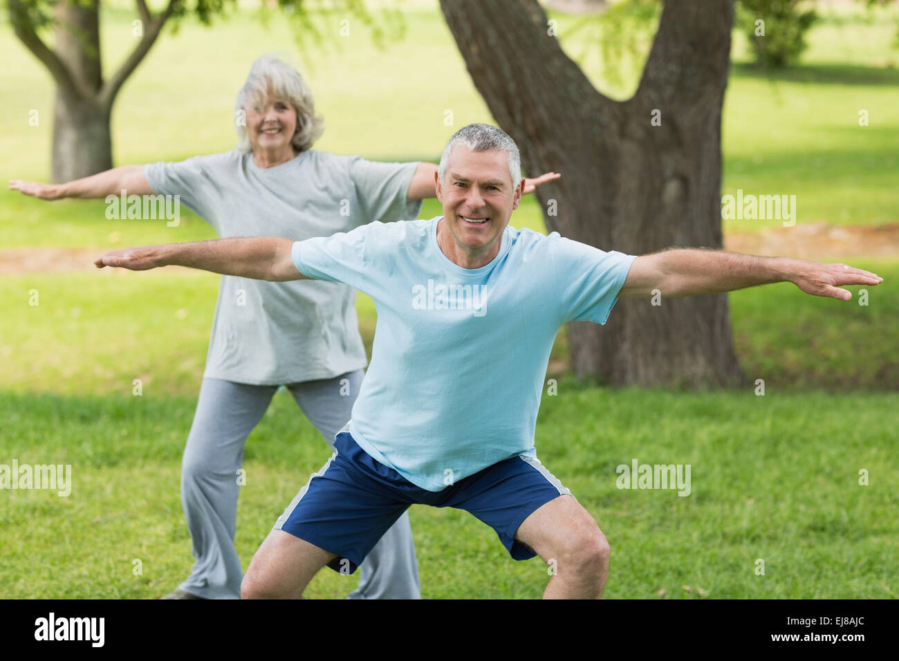 Smiling mature couple exercising at park Stock Photo - Alamy