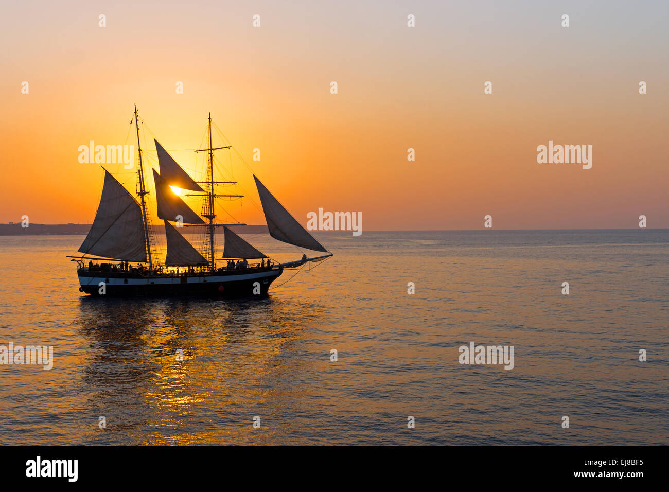 Romantic sunset with sailing ship Stock Photo