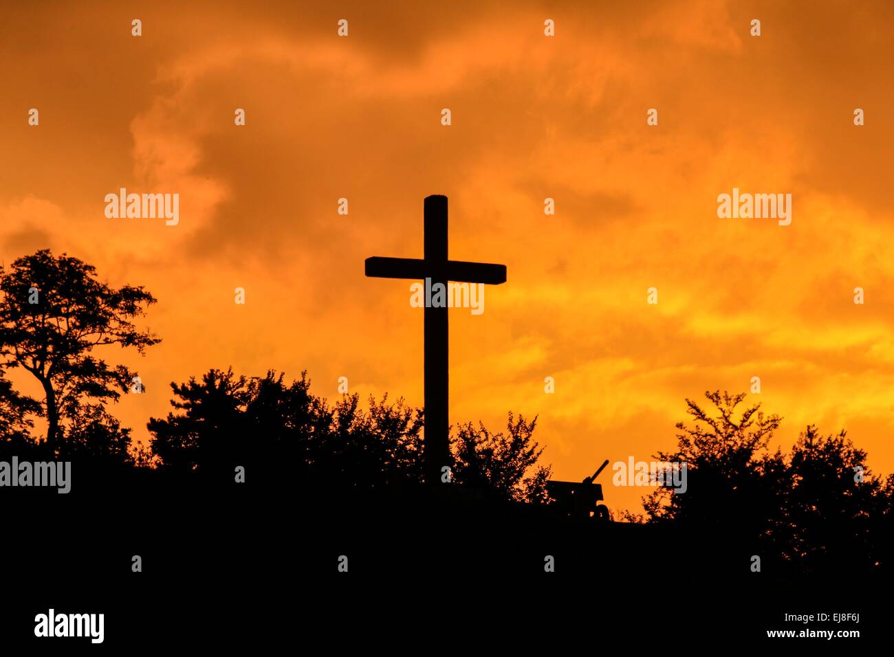 Sunrise over christian cross monument Stock Photo