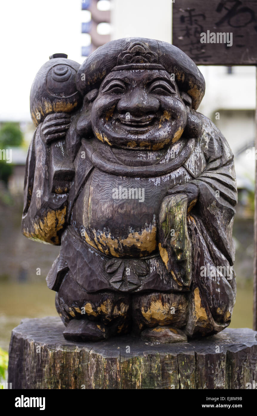 Wooden Lucky God Daikokuten statue next to Kajibashi bridge in Takayama, Gifu, Japan Stock Photo