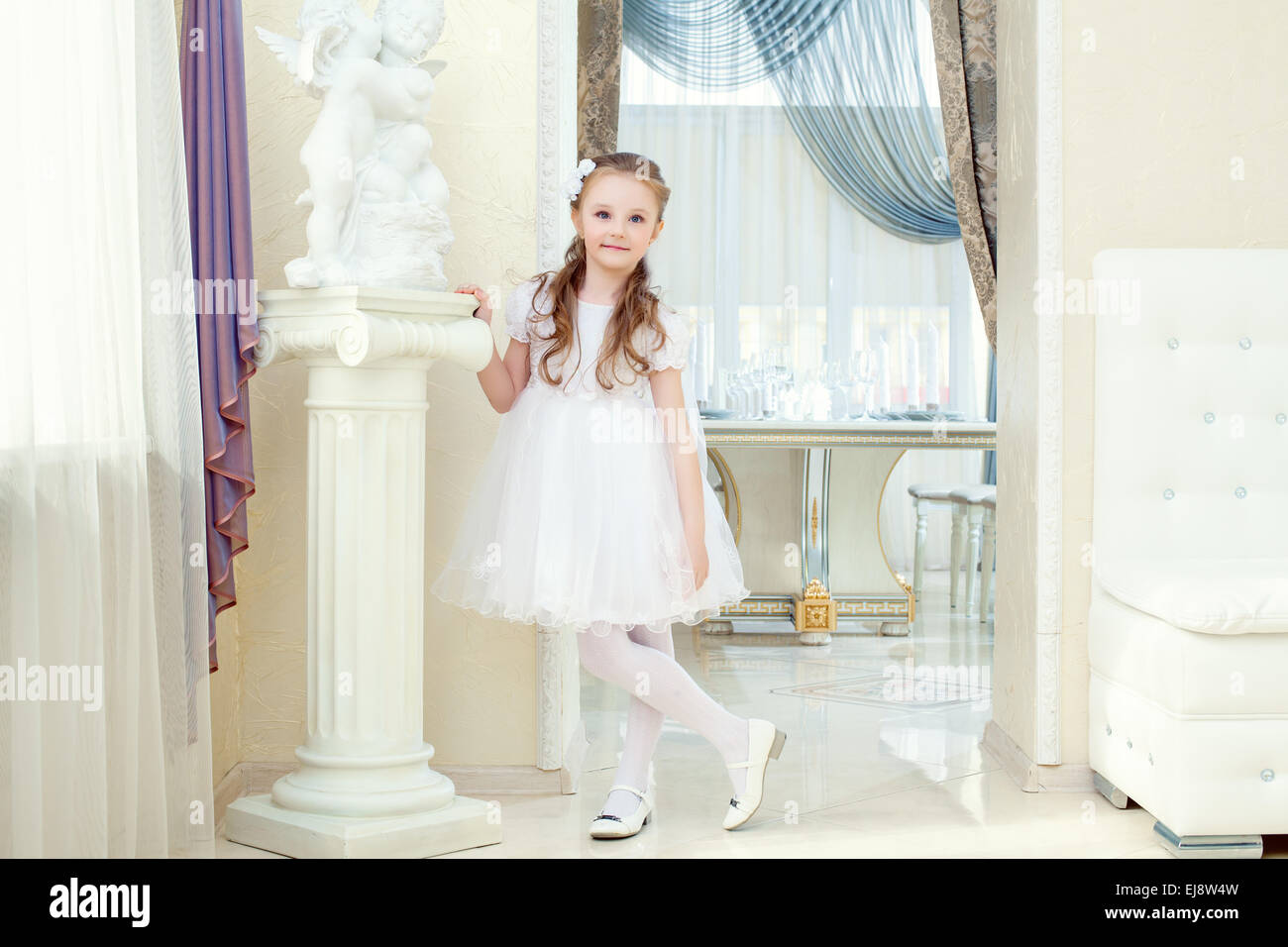 Adorable little girl posing in elegant dress Stock Photo - Alamy
