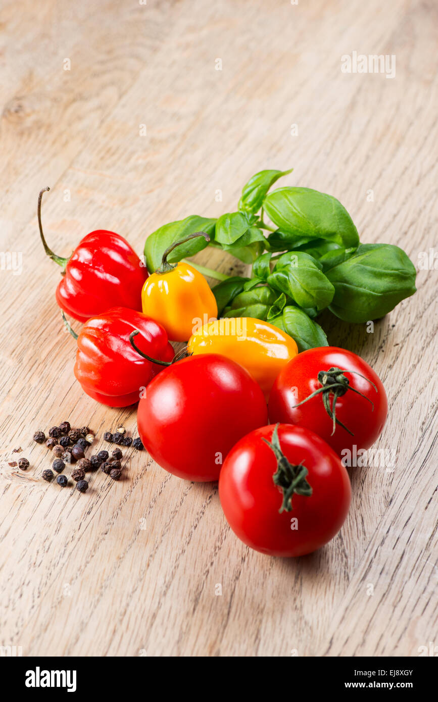 Peppers tomato and basil on table Stock Photo - Alamy