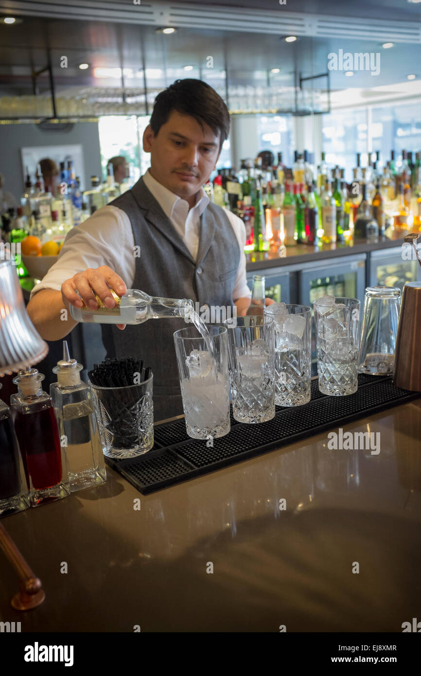 Barman pouring drinks at Gin Joint Restaurant by Searcys at the Barbican Centre London Stock Photo