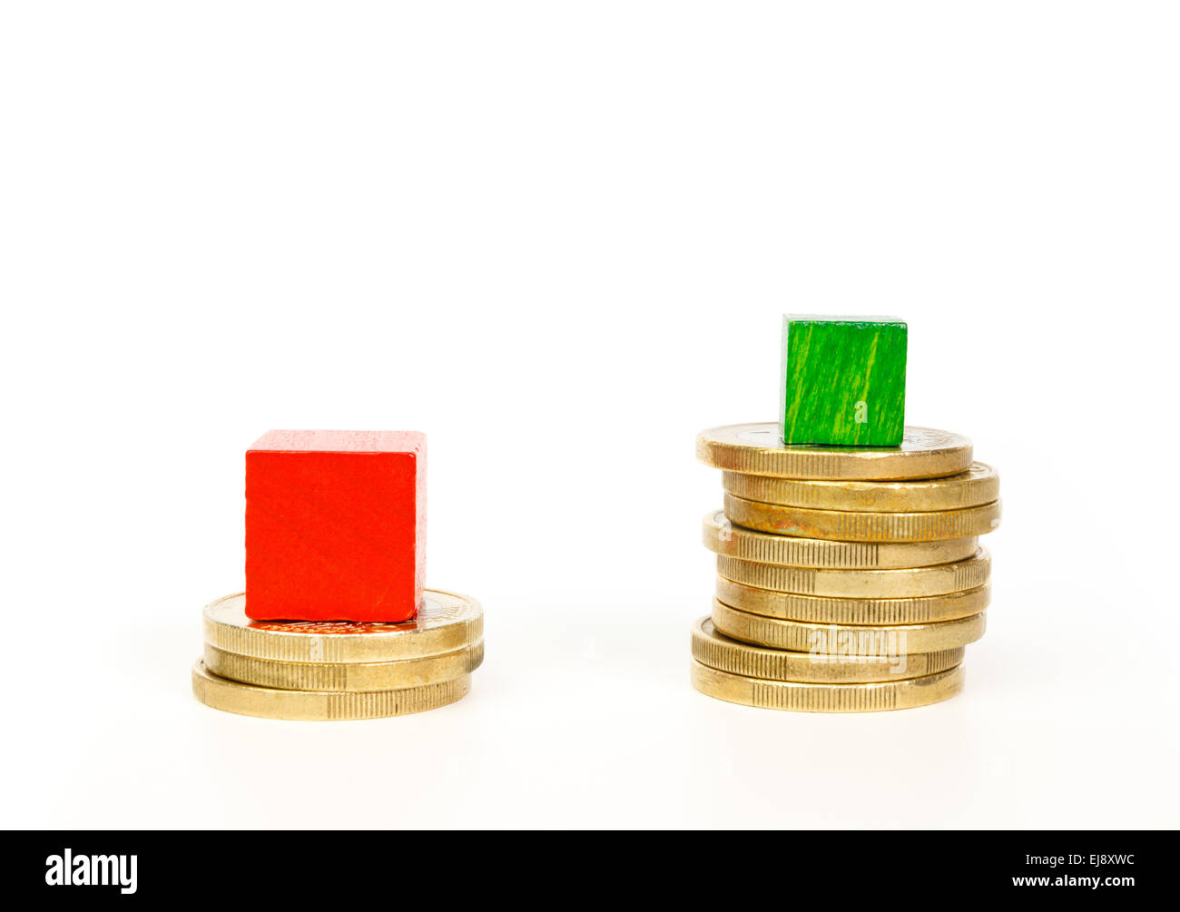 Difference in mortgage payments shown in stacks of coins and woodens cubes. Stock Photo