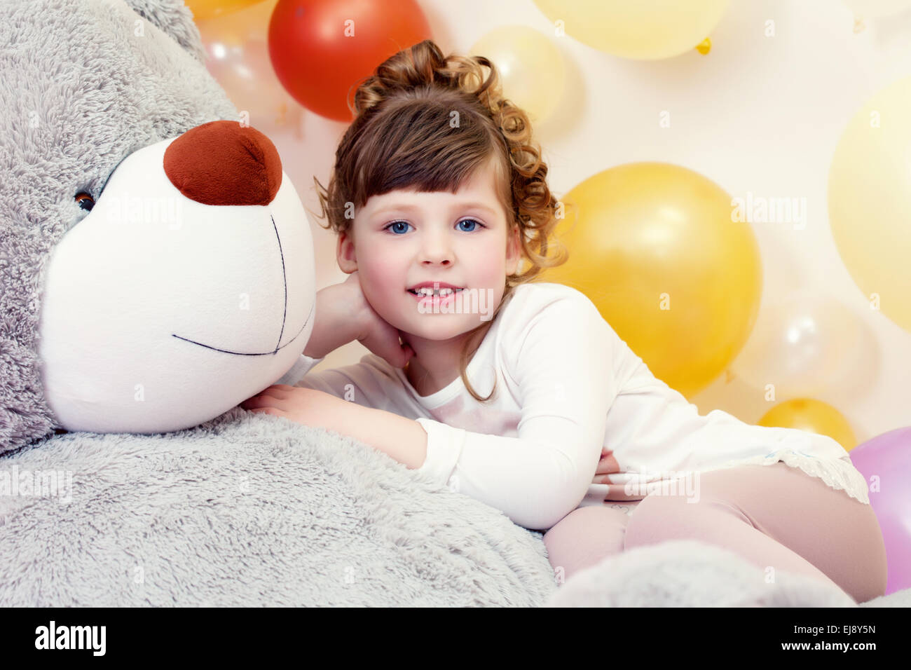 Adorable girl posing lying on teddy bear Stock Photo - Alamy