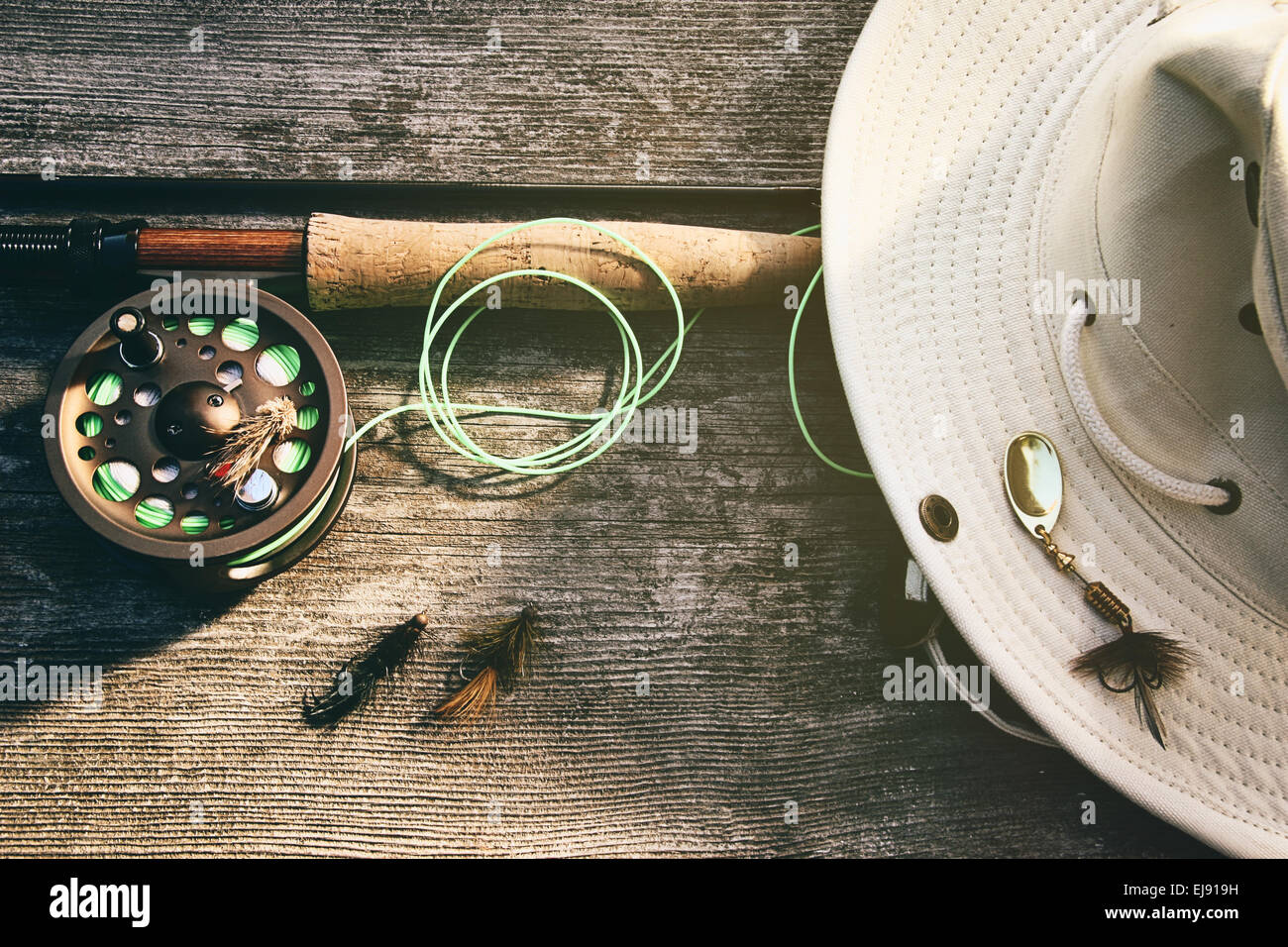 Fly fishing rod with hat on wood Stock Photo