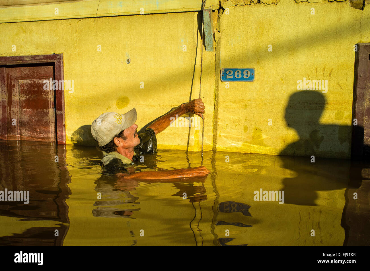 2015 flooding in Brazilian Amazon, flooded house. Joao Pereira de Araujo tries to check flood line inside his house at Triangulo Novo district, Rio Branco city, Acre State. Floods have been affecting thousands of people in the state of Acre, northern Brazil, since 23 February 2015, when some of the state’s rivers, in particular the Acre river, overflowed. Further heavy rainfall has forced river levels higher still, and on 03 March 2015 Brazil’s federal government declared a state of emergency in Acre State, where current flood situation has been described as the worst in 132 years. Stock Photo