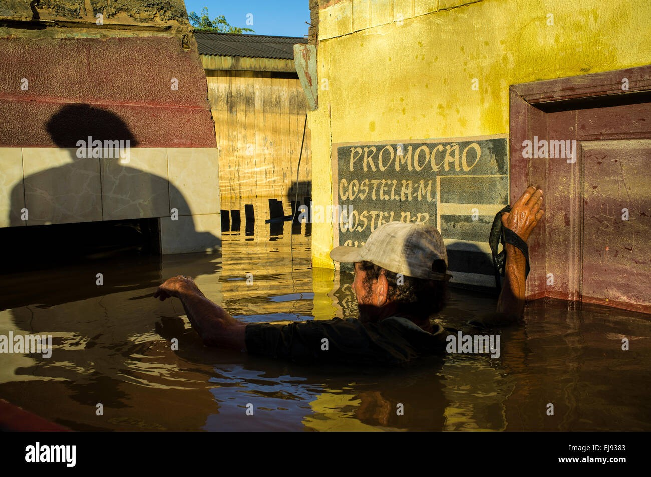2015 flooding in Brazilian Amazon. Joao Pereira de Araujo tries to check flood line inside his house at Triangulo Novo district, Rio Branco city, Acre State. Floods have been affecting thousands of people in the state of Acre, northern Brazil, since 23 February 2015, when some of the state’s rivers, in particular the Acre river, overflowed. Further heavy rainfall has forced river levels higher still, and on 03 March 2015 Brazil’s federal government declared a state of emergency in Acre State, where current flood situation has been described as the worst in 132 years. Stock Photo
