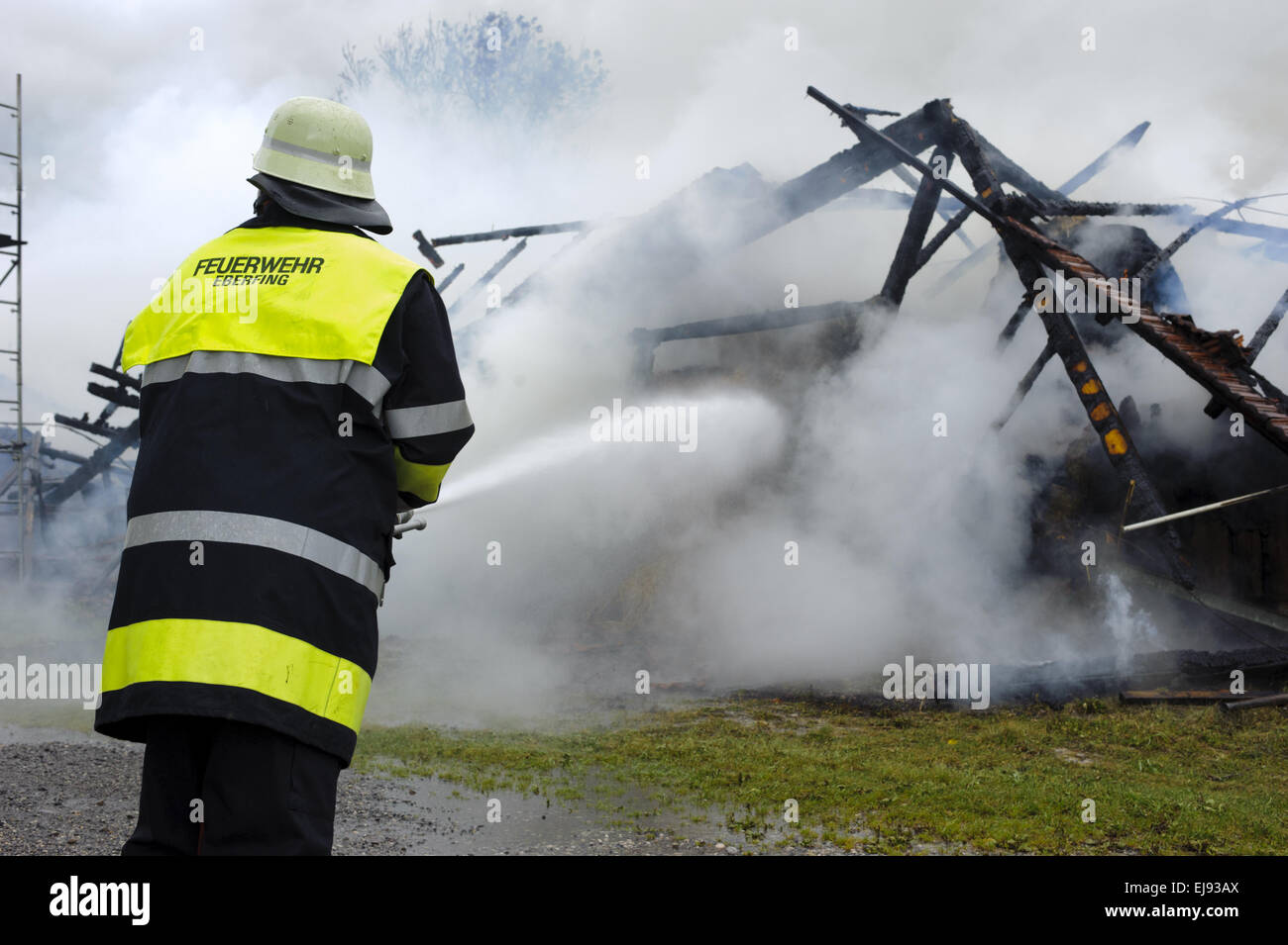 fireworker in action at burning house Stock Photo