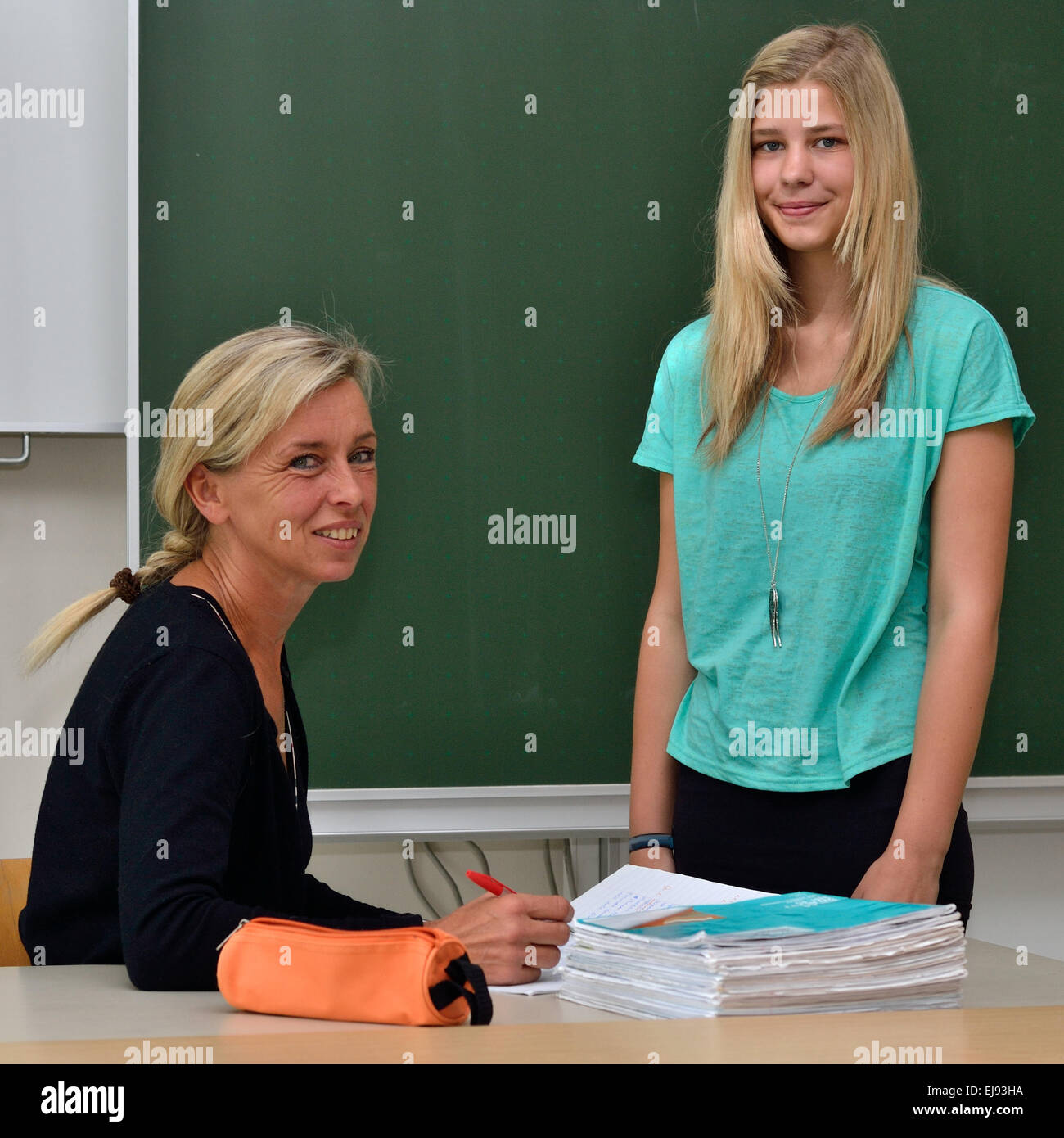 Teacher checks student with book Stock Photo