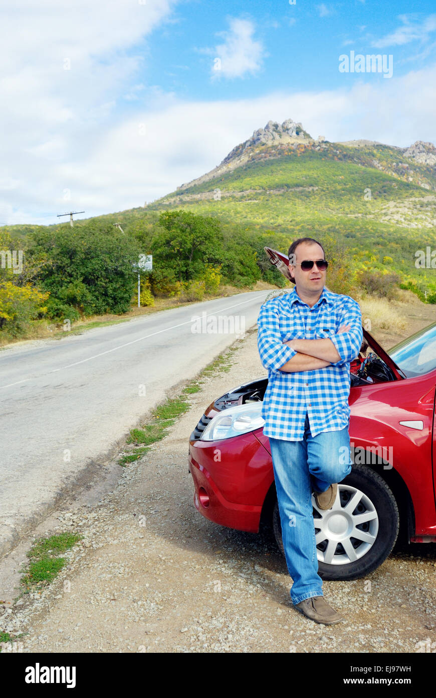 Adult man is standing near his broken car Stock Photo