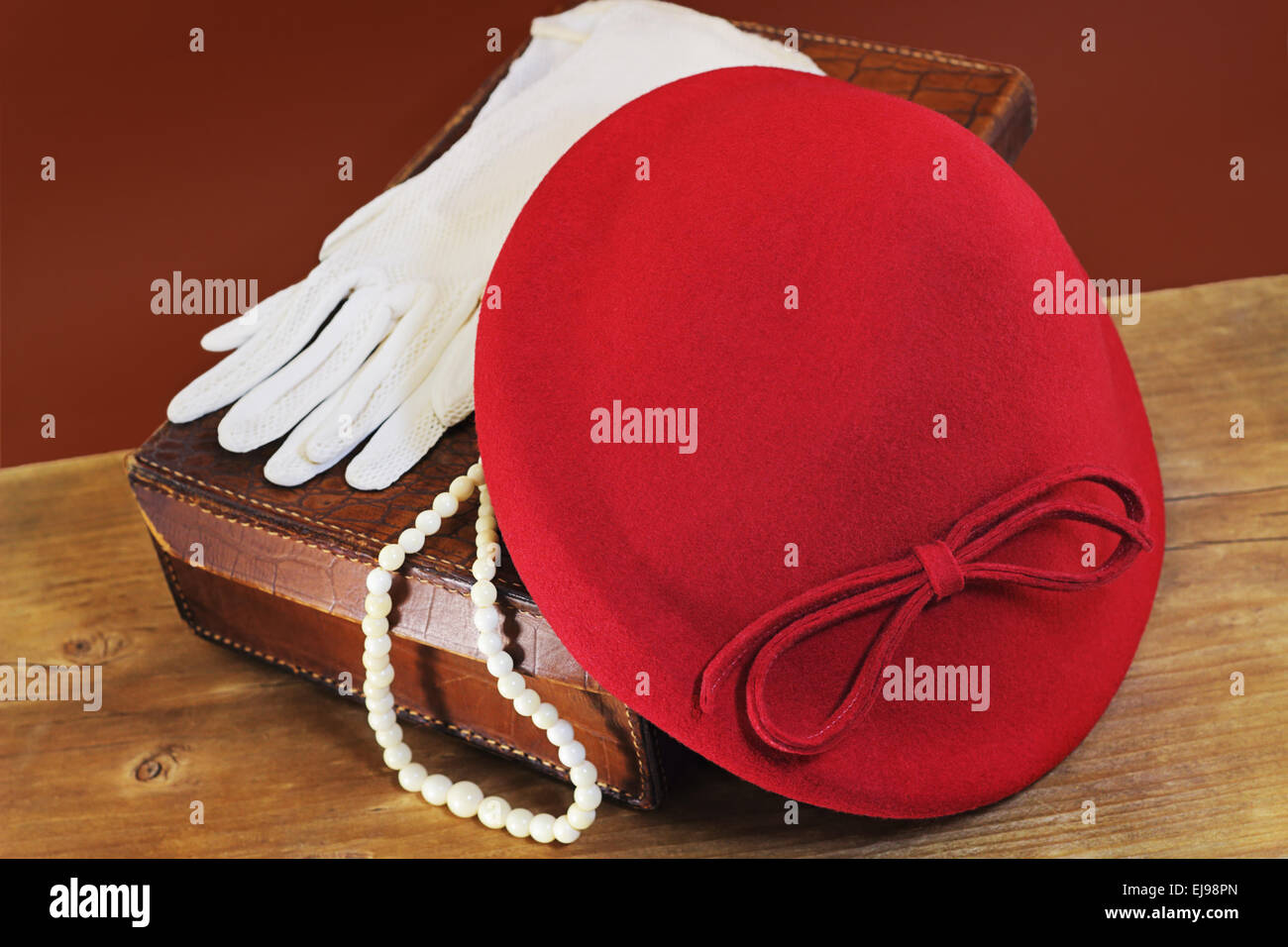 Red hat, white gloves and bone beads on leather case Stock Photo