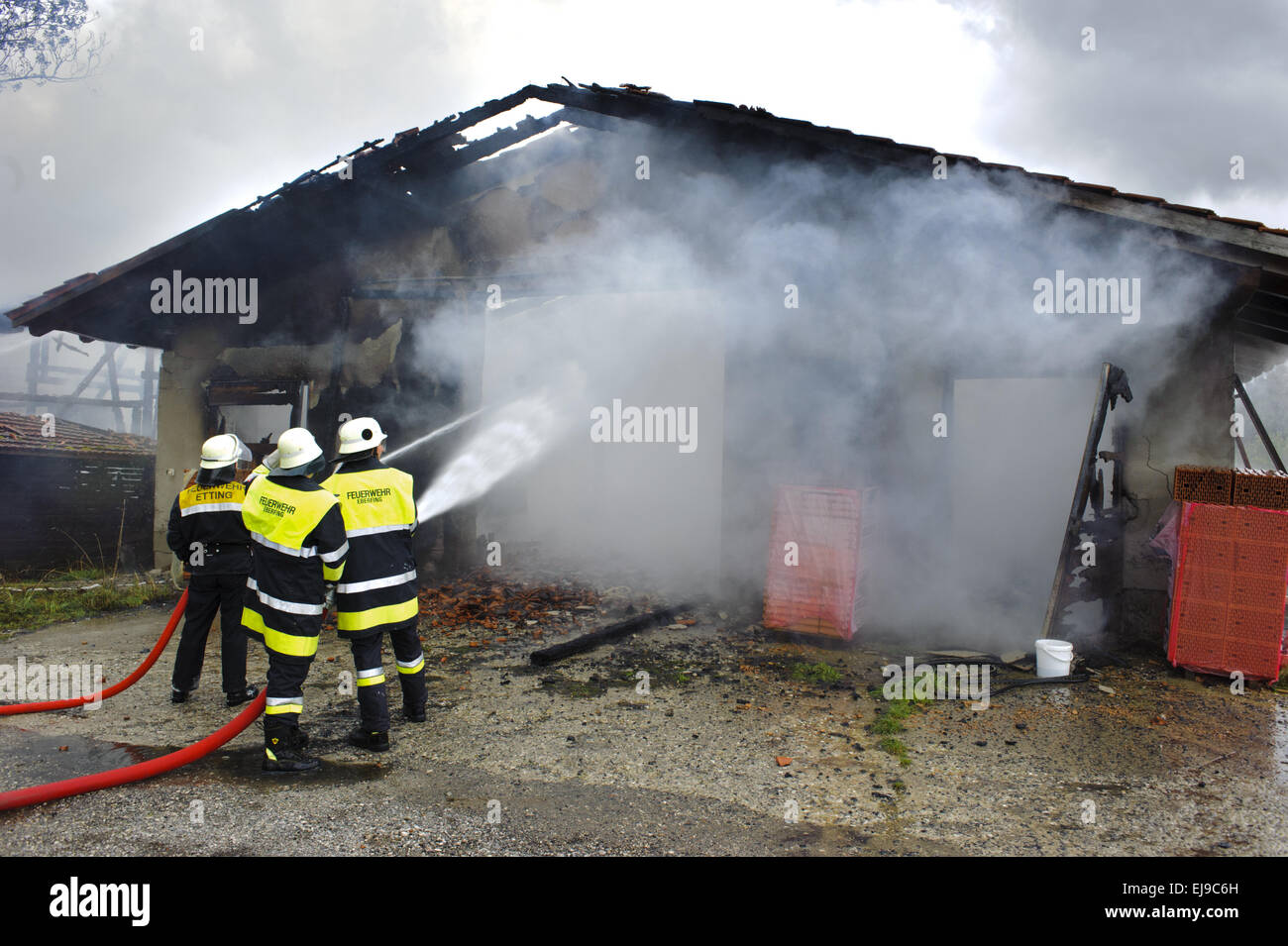 fireworker in action at burning house Stock Photo