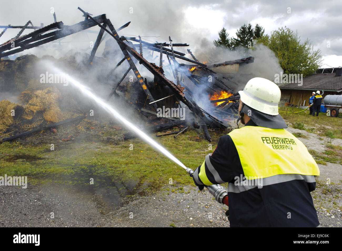 fireworker in action at burning house Stock Photo