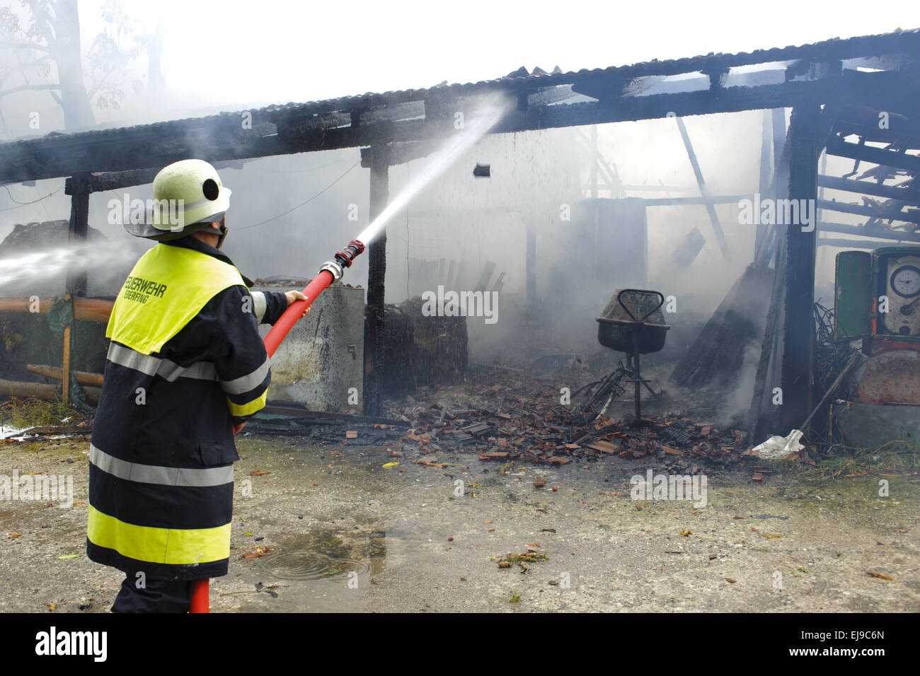 fireworker in action at burning house Stock Photo