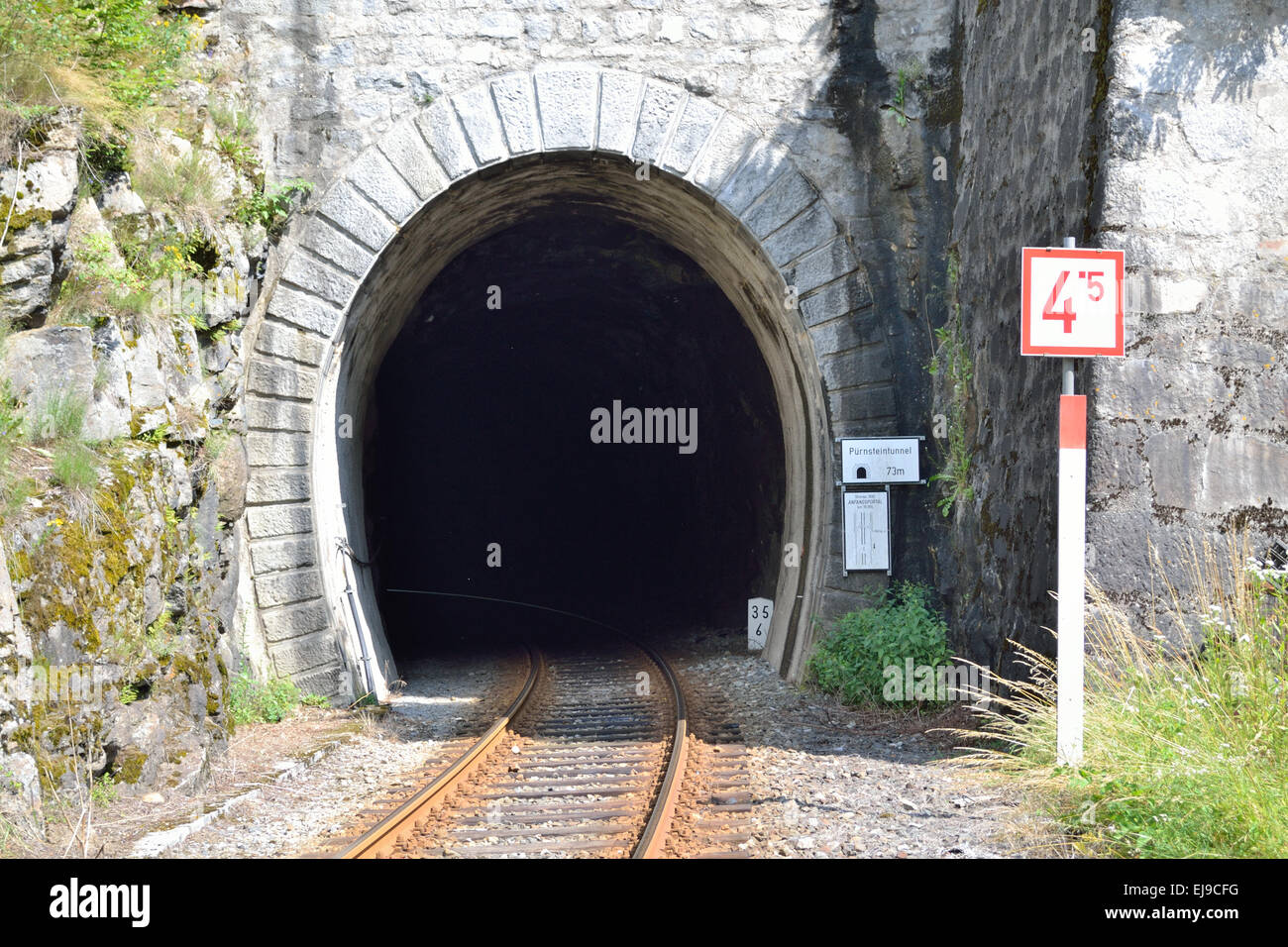 Train tracks leading into a tunnel Stock Photo