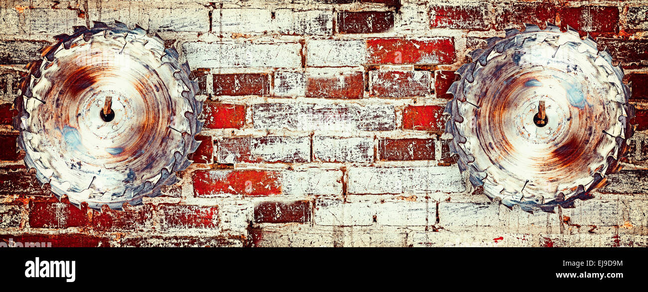 Circular saw blade on a grungy brick wall, background or texture Stock