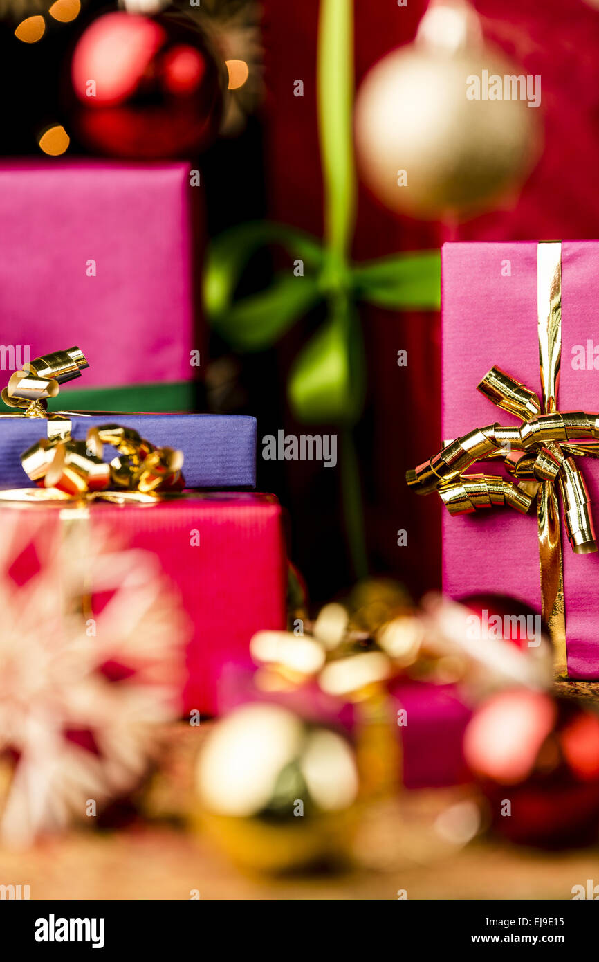 Magenta and Blue Gifts amidst Golden Glitter Stock Photo
